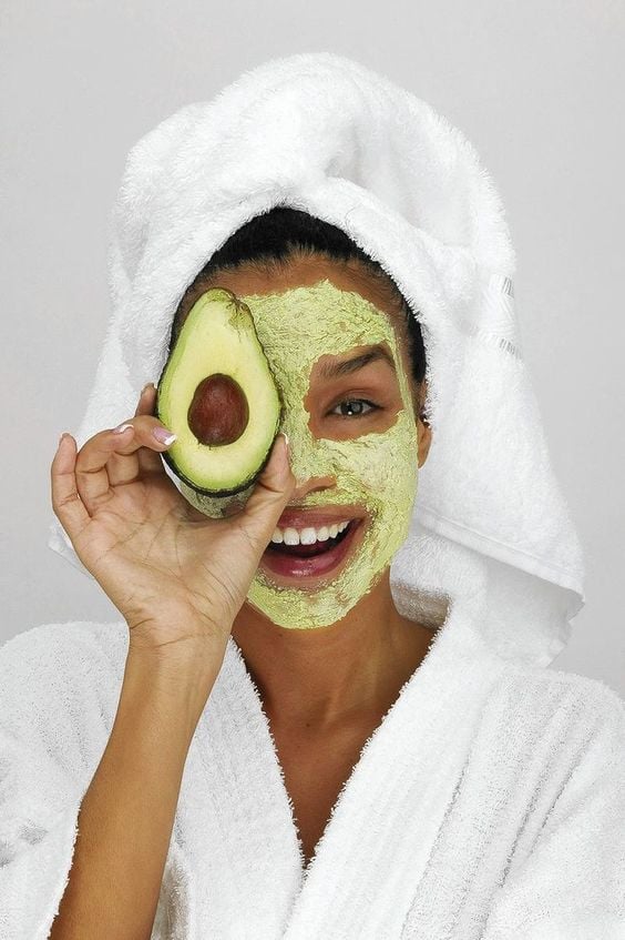 Chica usando una mascarilla de aguacate 