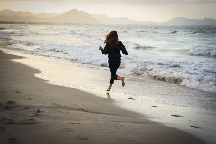 chica corriendo por la playa 