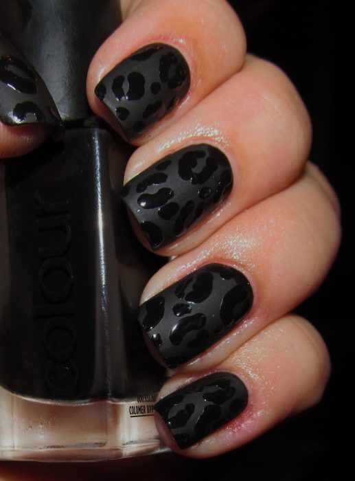 Uñas decoradas con un esmalte negro mate y gotas de color negro brillante 