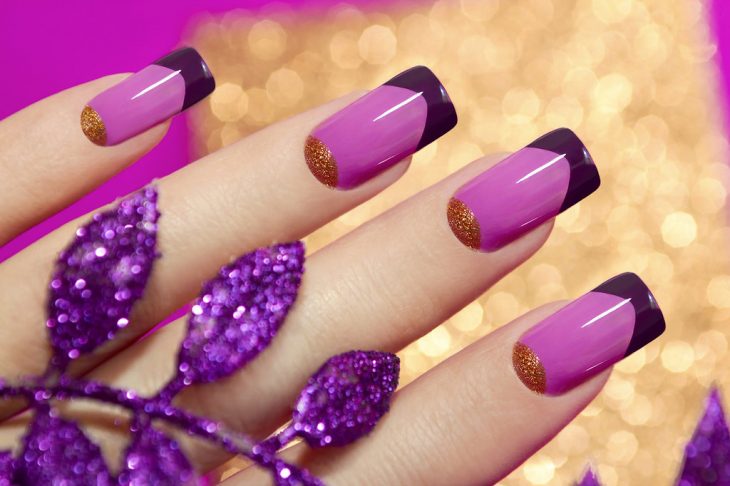 Uñas decoradas con esmaltes en rosa, morado y dorado 