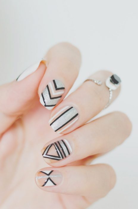 Uñas de color blanco con diseños de lineas en negro 