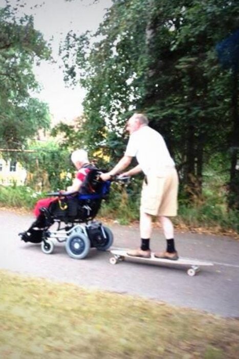 Pareja de viejitos jugando con una patineta 