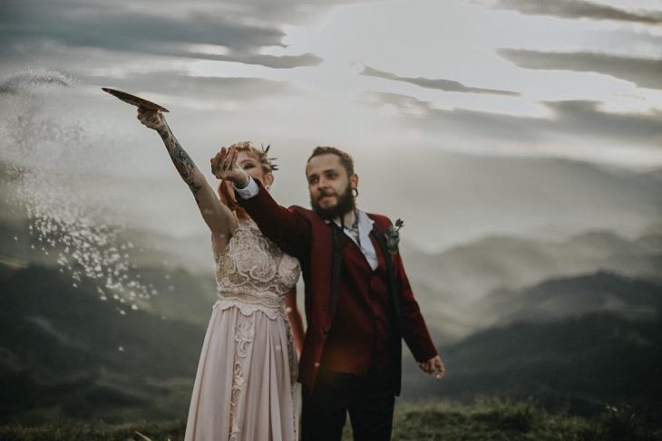 Pareja de novios celebra una boda nórdica al aire libre, novios vikingos arrojan sal al aire