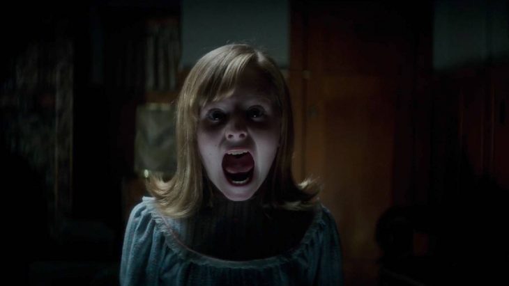 Niña con pijama azul gritando y asustada escena de la película Ouija: el origen del mal 