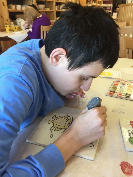 Daniel Dublin, chico con autismo, dibujando con pintura plástica 