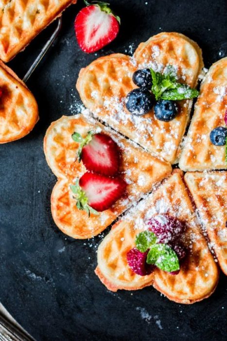 Waffles con chocolate cubiertos de fruta y azúcar glas 