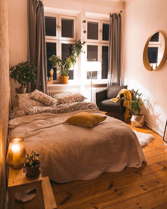 Organización de habitación pequeña con estilo de colores blancos y piso de madera con un sofá