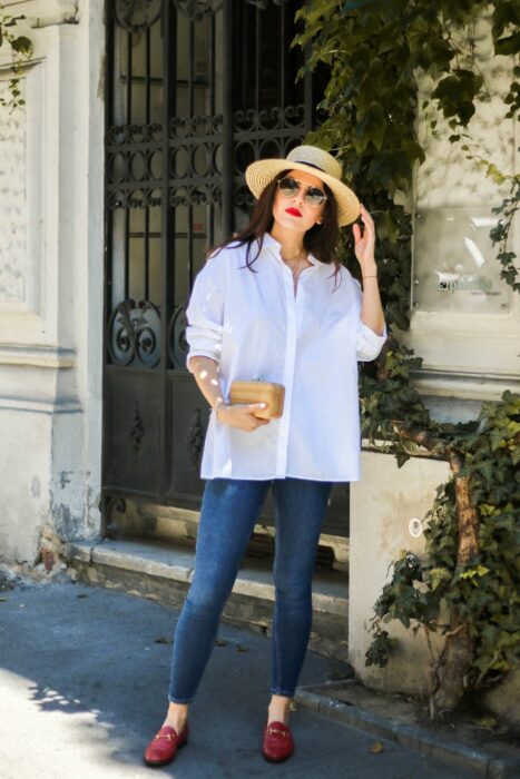Chica usando una camisa de color blanca con jeans, sombrero y flats 