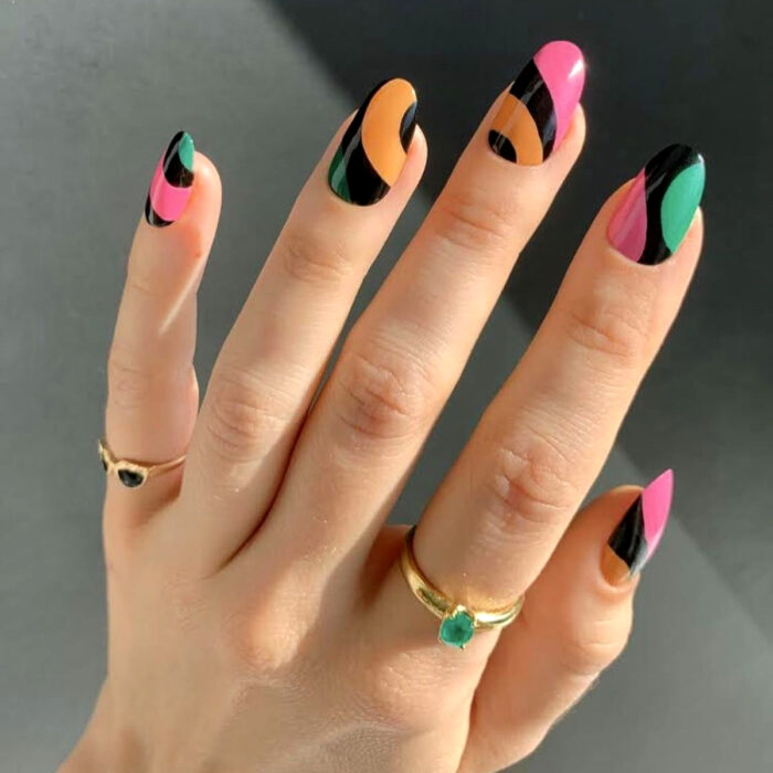 Diseños bonitos de manicura coloridos; uñas largas redondas pintadas con esmaltes de colores negro, rosa, verde y anaranjado, anillos sencillos de piedras
