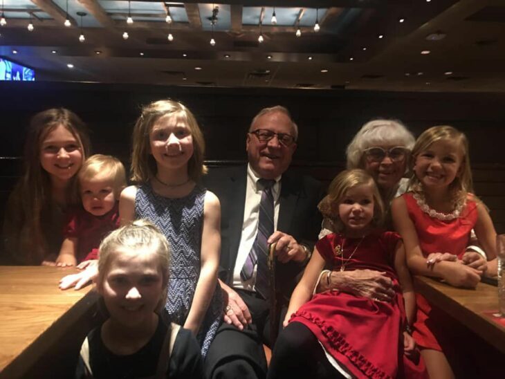 Photograph of grandparents surrounded by their grandchildren